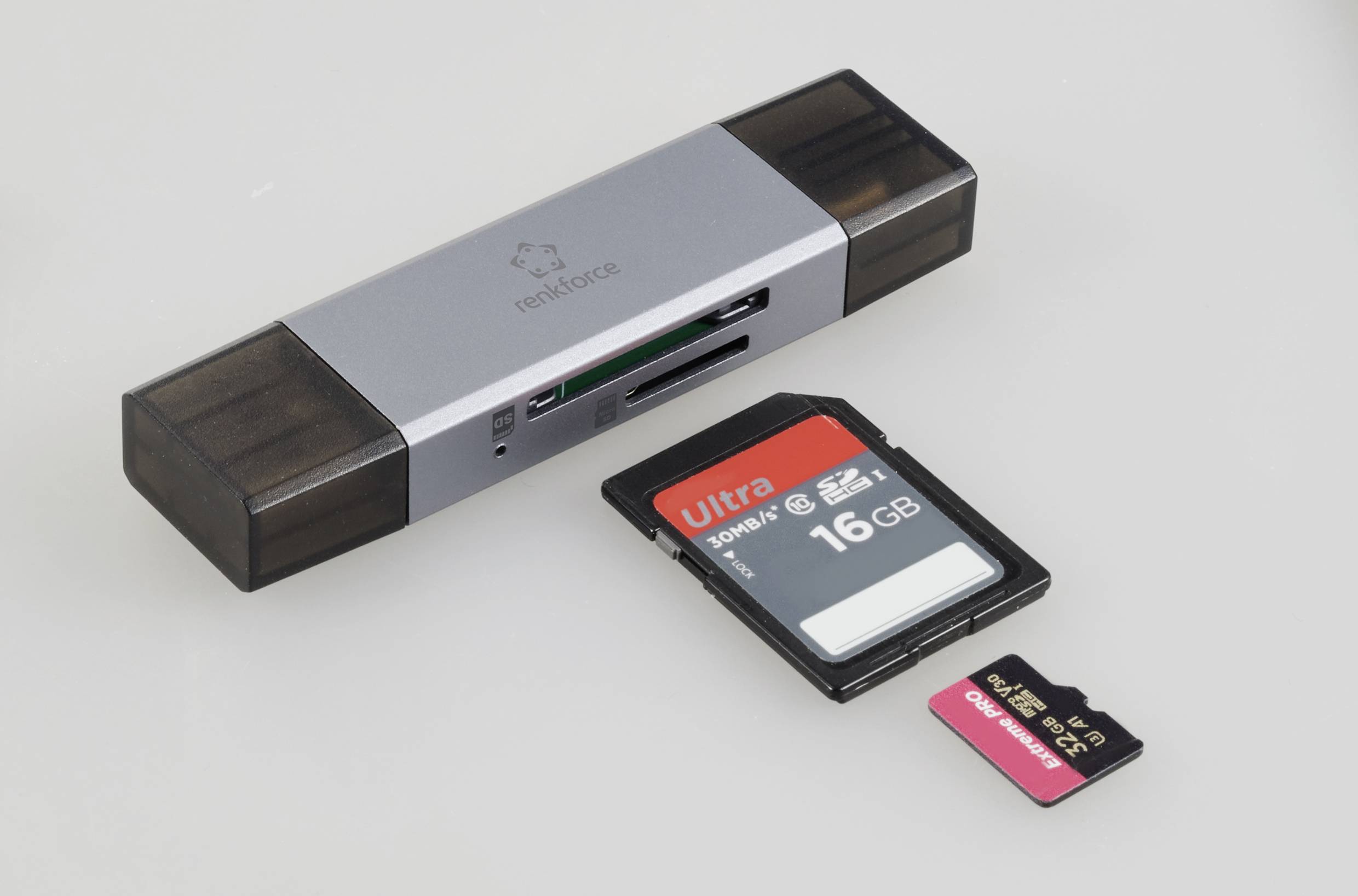 Ein USB-Kartenleser mit zwei SD-Karten, eine 16 GB und eine kleinere MicroSD-Karte, liegt daneben.