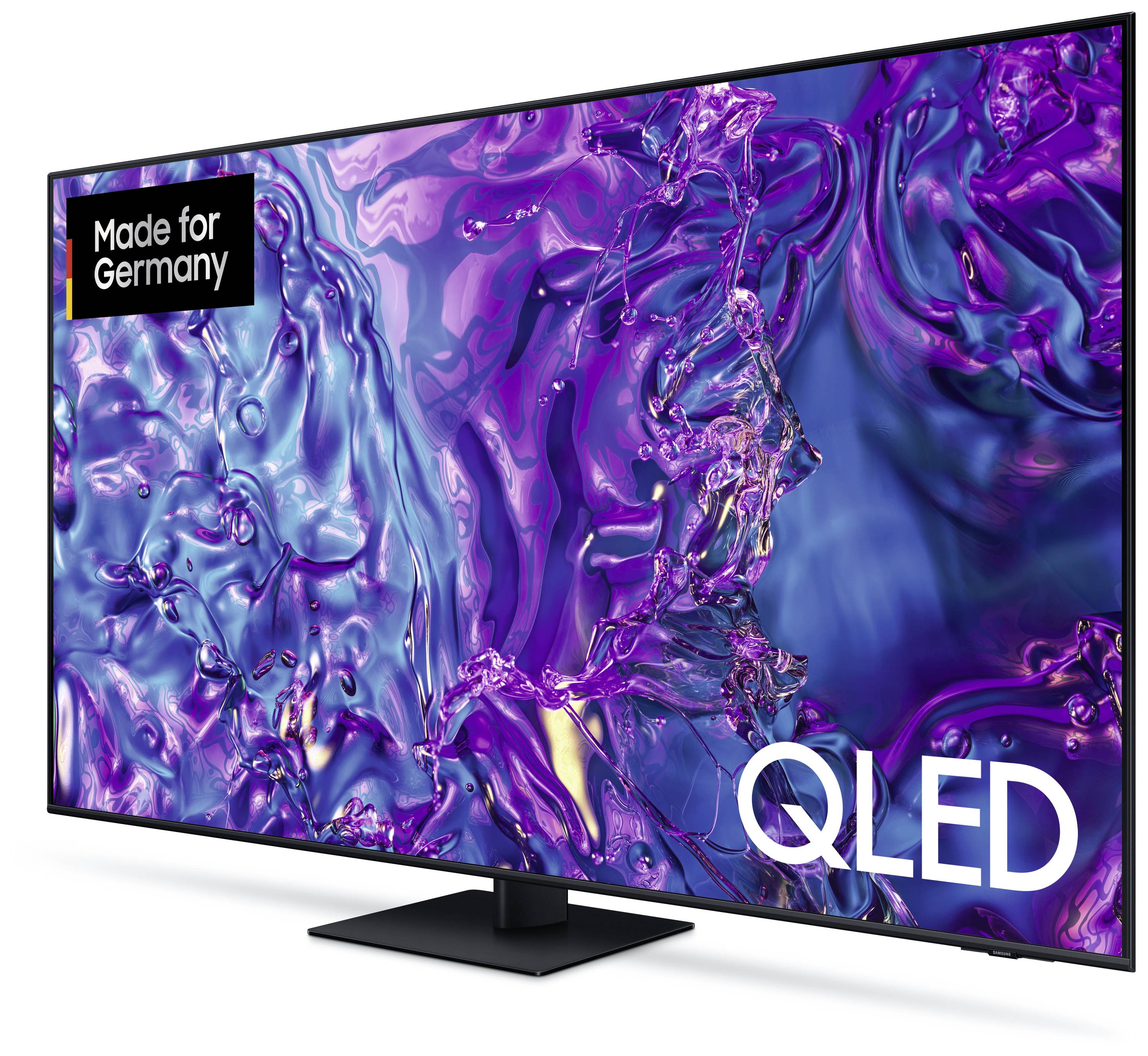 QLED-Fernseher mit großem Display zeigt abstrakte, farbenfrohe Muster in Violett- und Blautönen. Aufschrift: 'Made for Germany'.