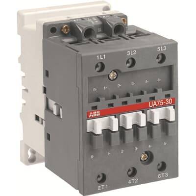 Ein grauer elektrischer Schütz mit drei roten Tasten und mehreren Anschlussklemmen ist abgebildet.