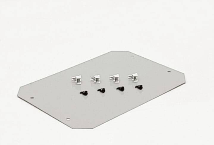 Ein rechteckiges Metallblech mit acht kleinen Befestigungselementen in zwei Reihen, vier silberne oben und vier schwarze unten.