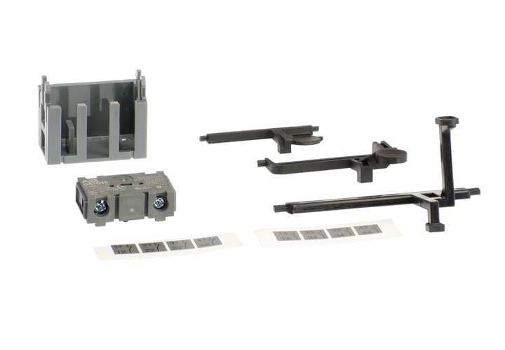 Mehrere Bauteile, darunter graue und schwarze Halterungen und Kleinteile, liegen auf weißem Hintergrund.