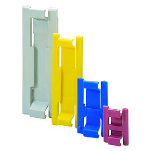 Vier farbige Plastikclips in verschiedenen Größen, von links nach rechts: Weiß, Gelb, Blau, Rosa. Stehend in einer Reihe.