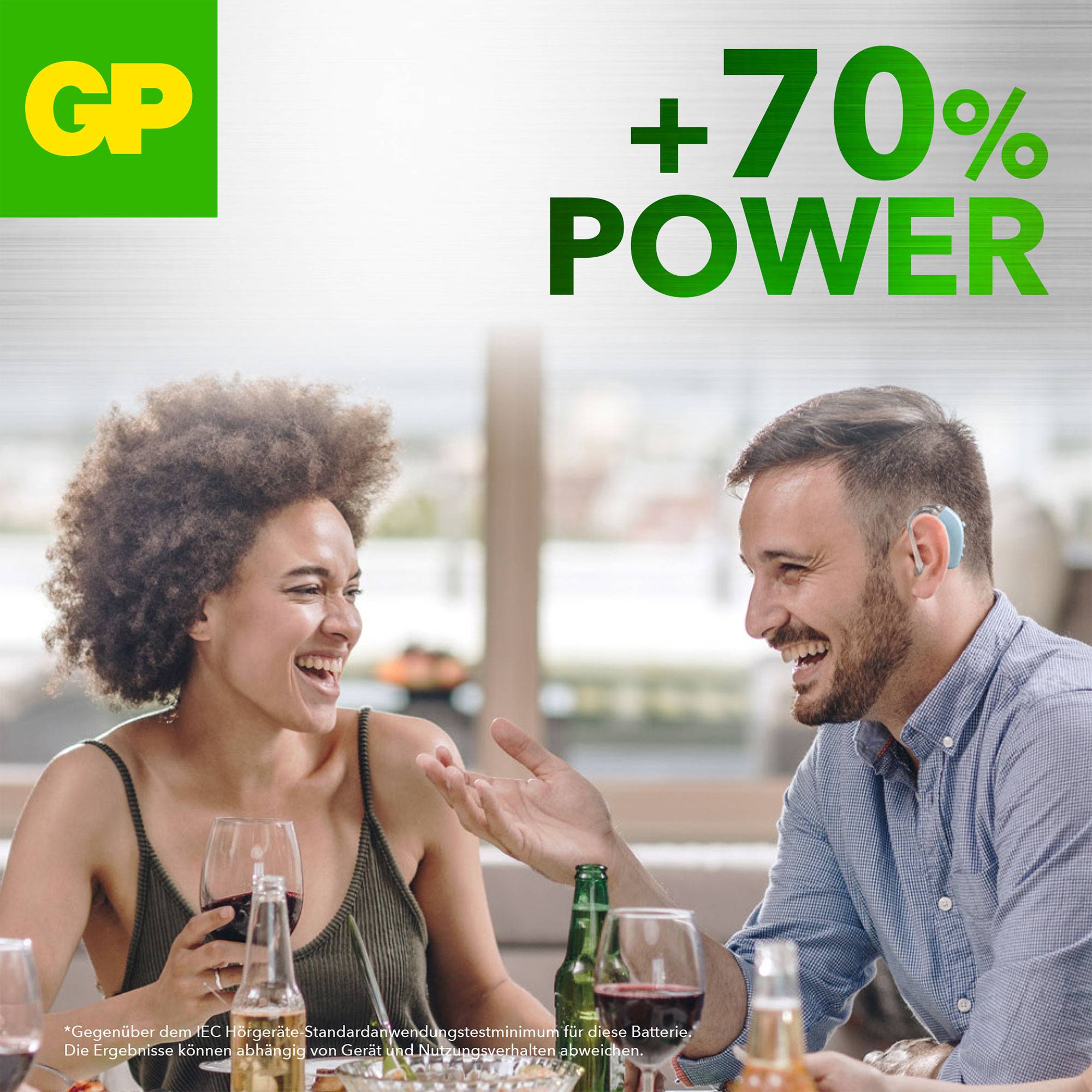 Ein lachendes Paar sitzt im Café. Text '70% mehr Power' und 'Ergebnisse können je nach Gerät und Nutzungsmuster abweichen'.