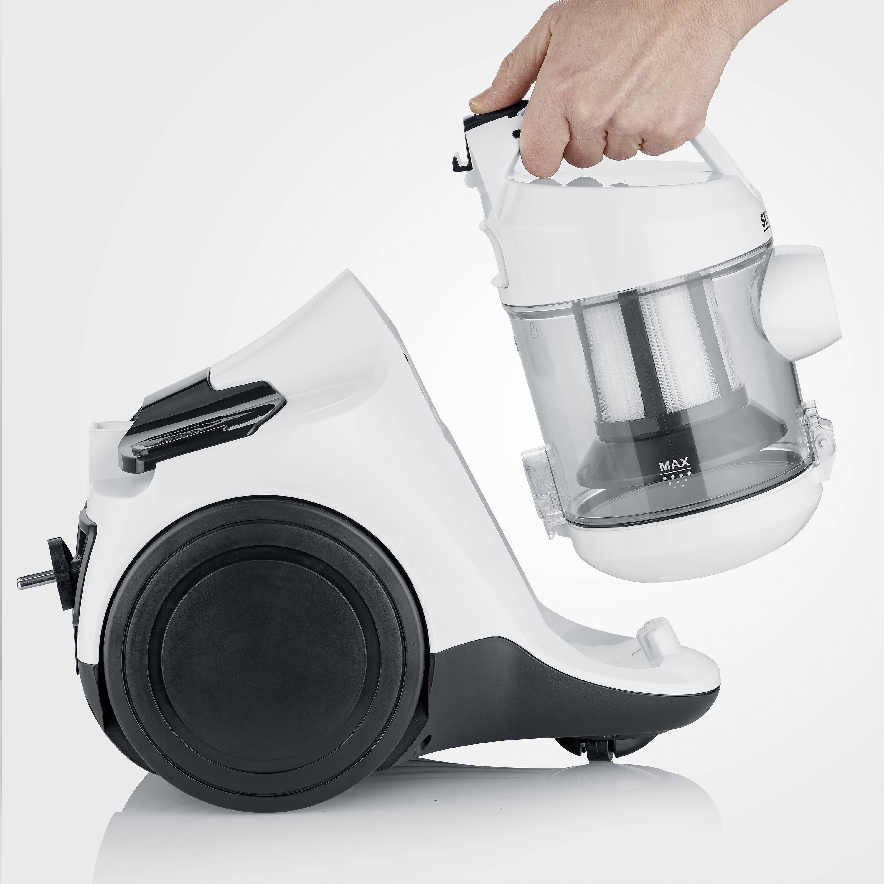Eine Hand hält einen weißen, beutellosen Staubsauger mit transparenter Staubkammer. Der Staubsauger hat ein großes schwarzes Rad.