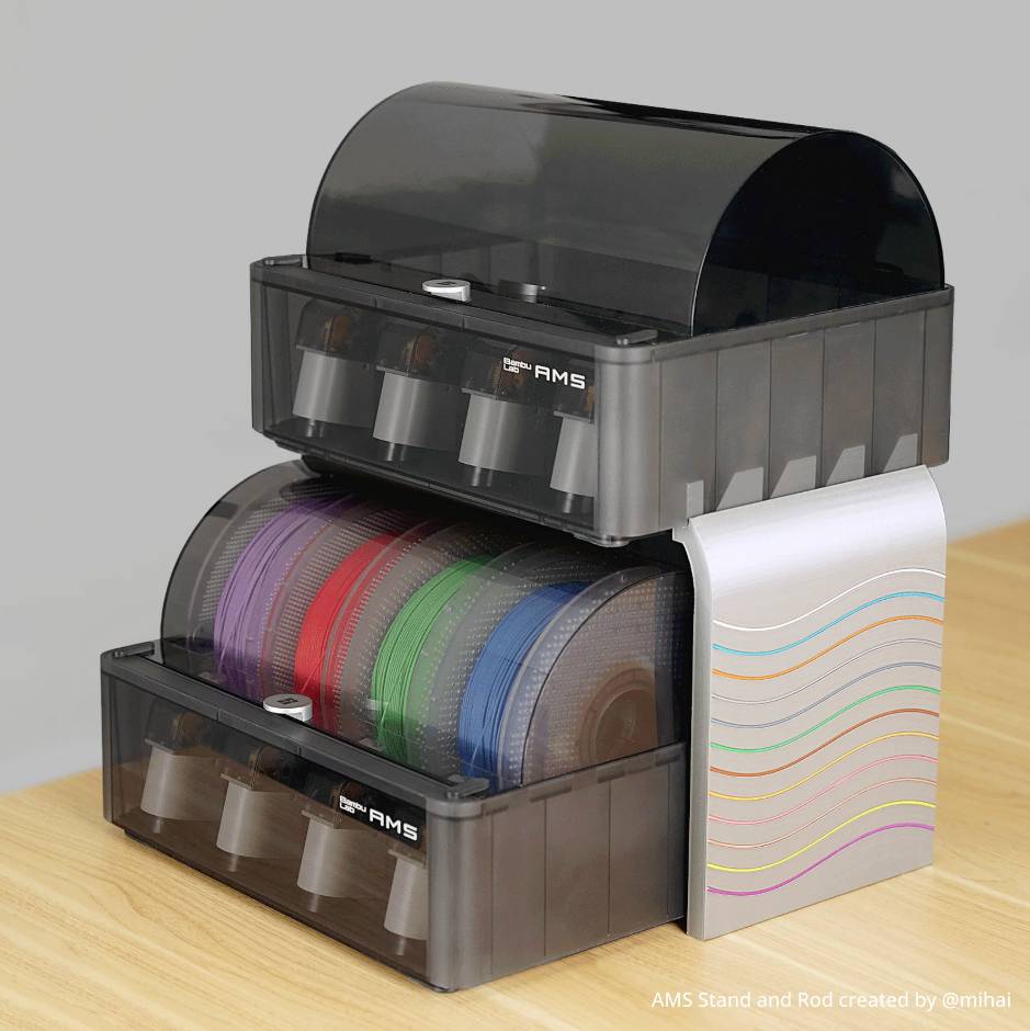 Zwei schwarze Filamenthalter mit Rollen in verschiedenen Farben, übereinander gestapelt auf einem Holztisch.