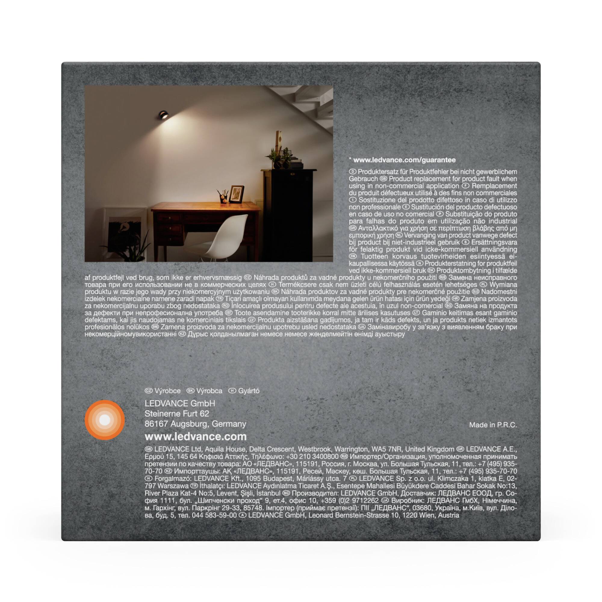 Eine Lampe beleuchtet einen stilvollen Arbeitsplatz mit einem Schreibtisch und Stuhl vor einer Wand. Ledvance-Produktbeschreibung darunter.