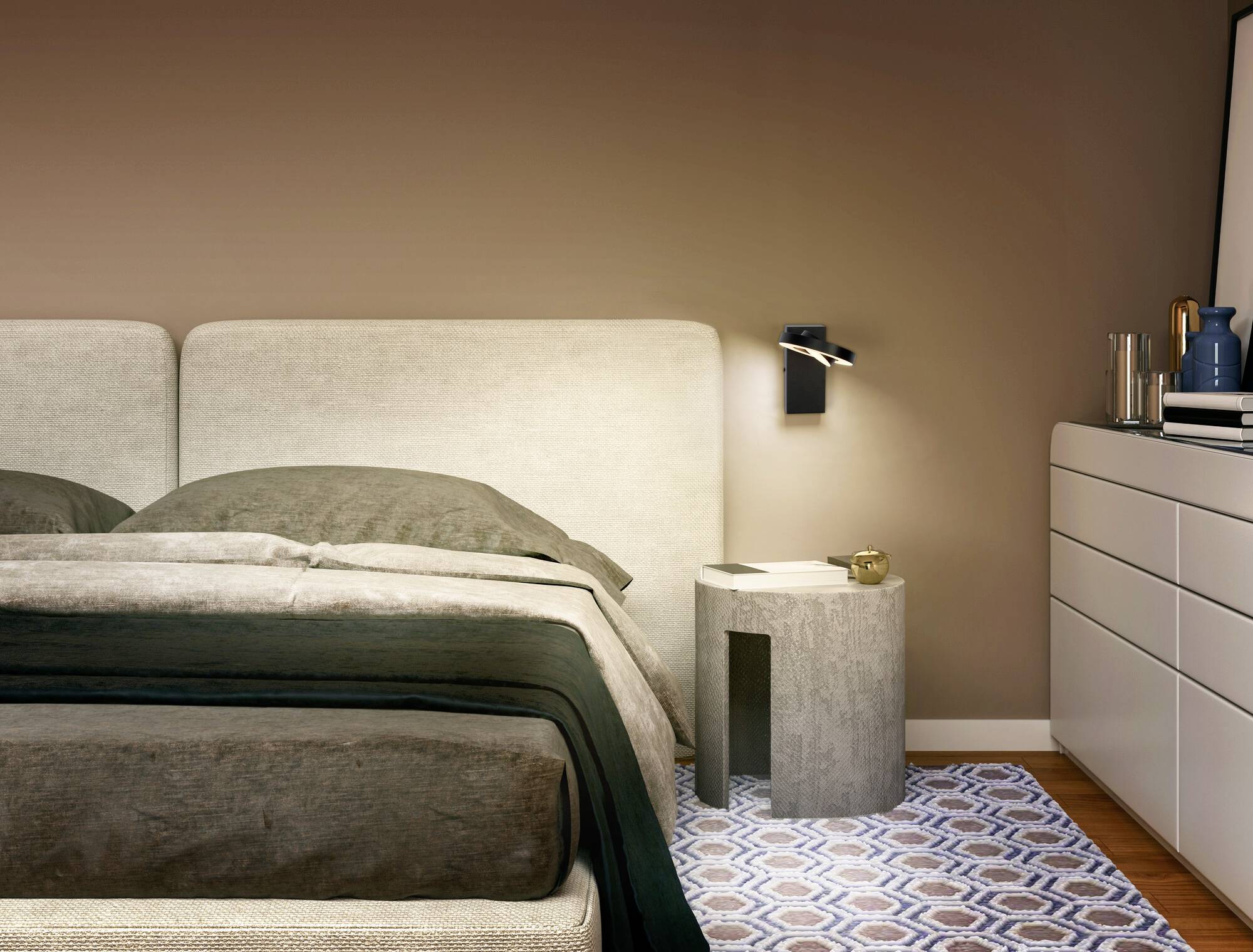 Modernes Schlafzimmer mit grauem Bett, Nachttisch und Wandleuchte. Der Raum wirkt einladend und elegant.