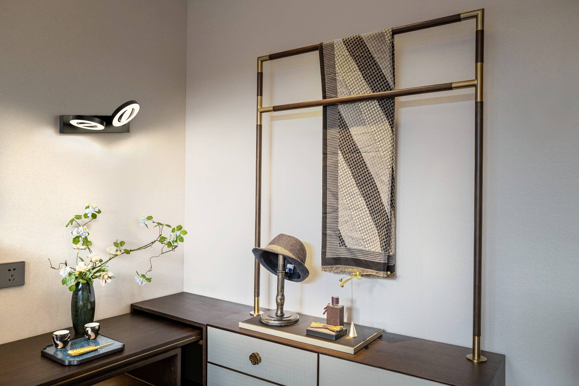 Ein modern eingerichtetes Zimmer. Ein Hut auf einem Tisch; daneben ein dekoratives Wandtuch. Auf dem Tisch befinden sich kleine Accessoires.