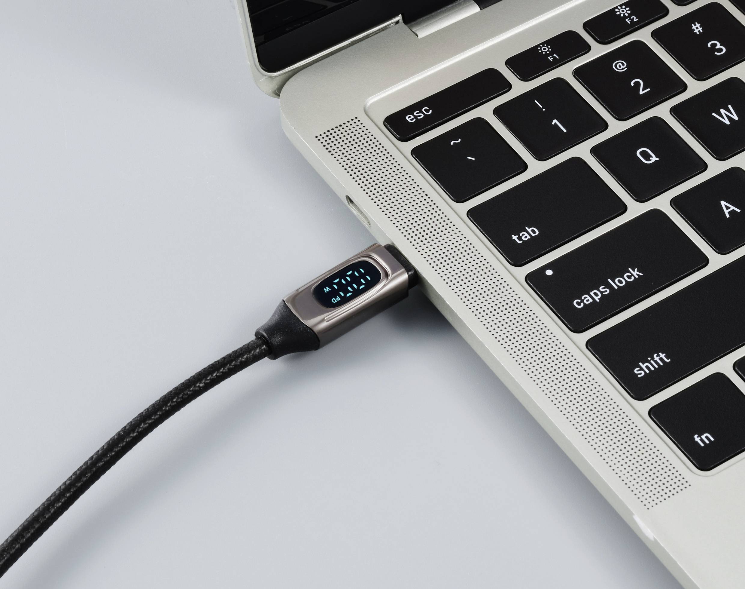 Ein Laptop mit angeschlossener Ladekabel im USB-Anschluss. Der Bildschirm ist nicht sichtbar. Es symbolisiert das Aufladen eines Gerätes.