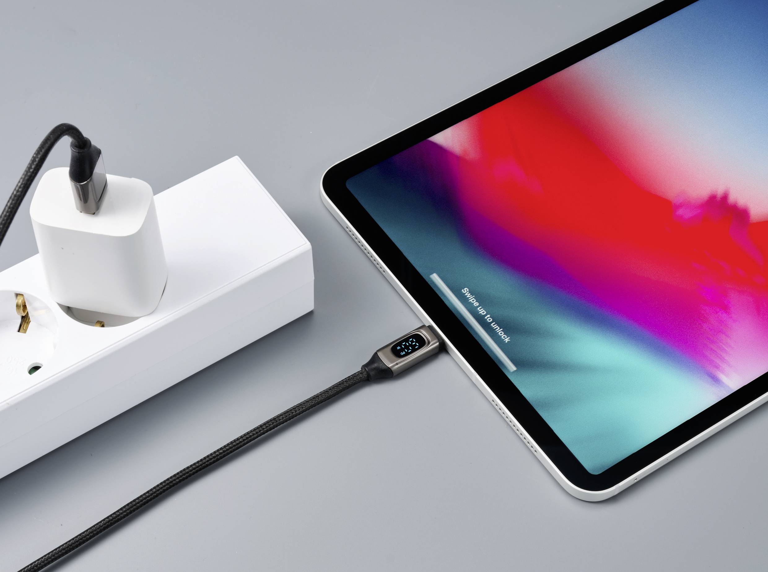 Ein Tablet wird mit einem Ladekabel, das an eine Steckdose angeschlossen ist, geladen. Ein Ladezustandsanzeiger am Kabel zeigt 92%.