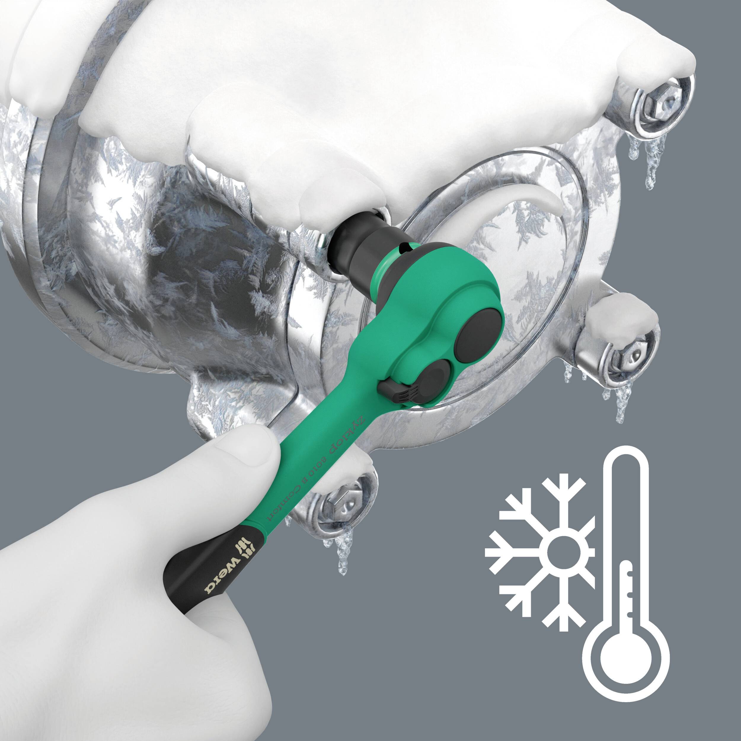 Eine Hand hält einen vereisten Schraubenschlüssel, der ein eisbedecktes Ventil versucht zu drehen. Symbol eines Thermometers und einer Schneeflocke deutet auf Kälte hin.