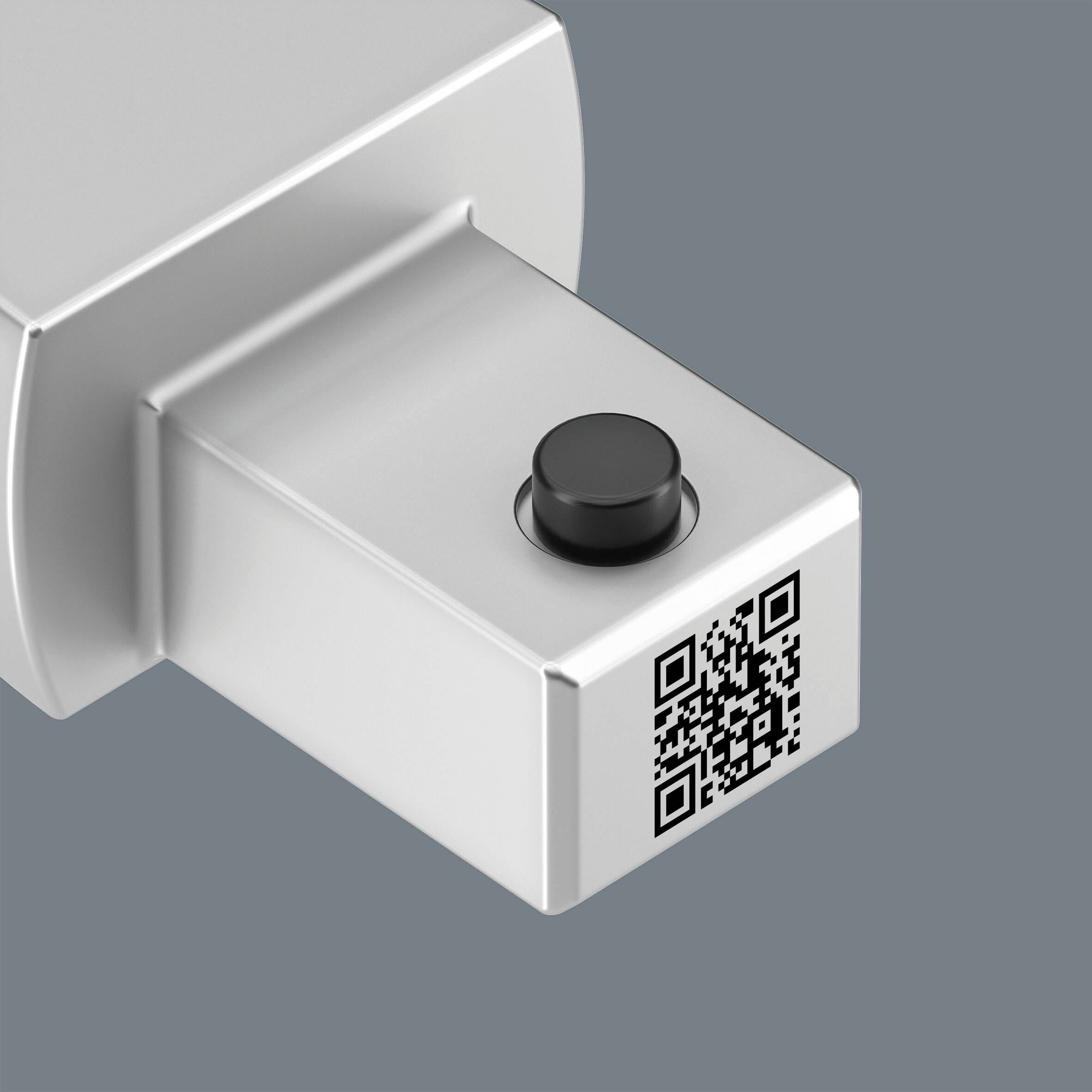 Ein USB-Stick aus Metall mit einem QR-Code auf der Vorderseite, vor einem grauen Hintergrund.