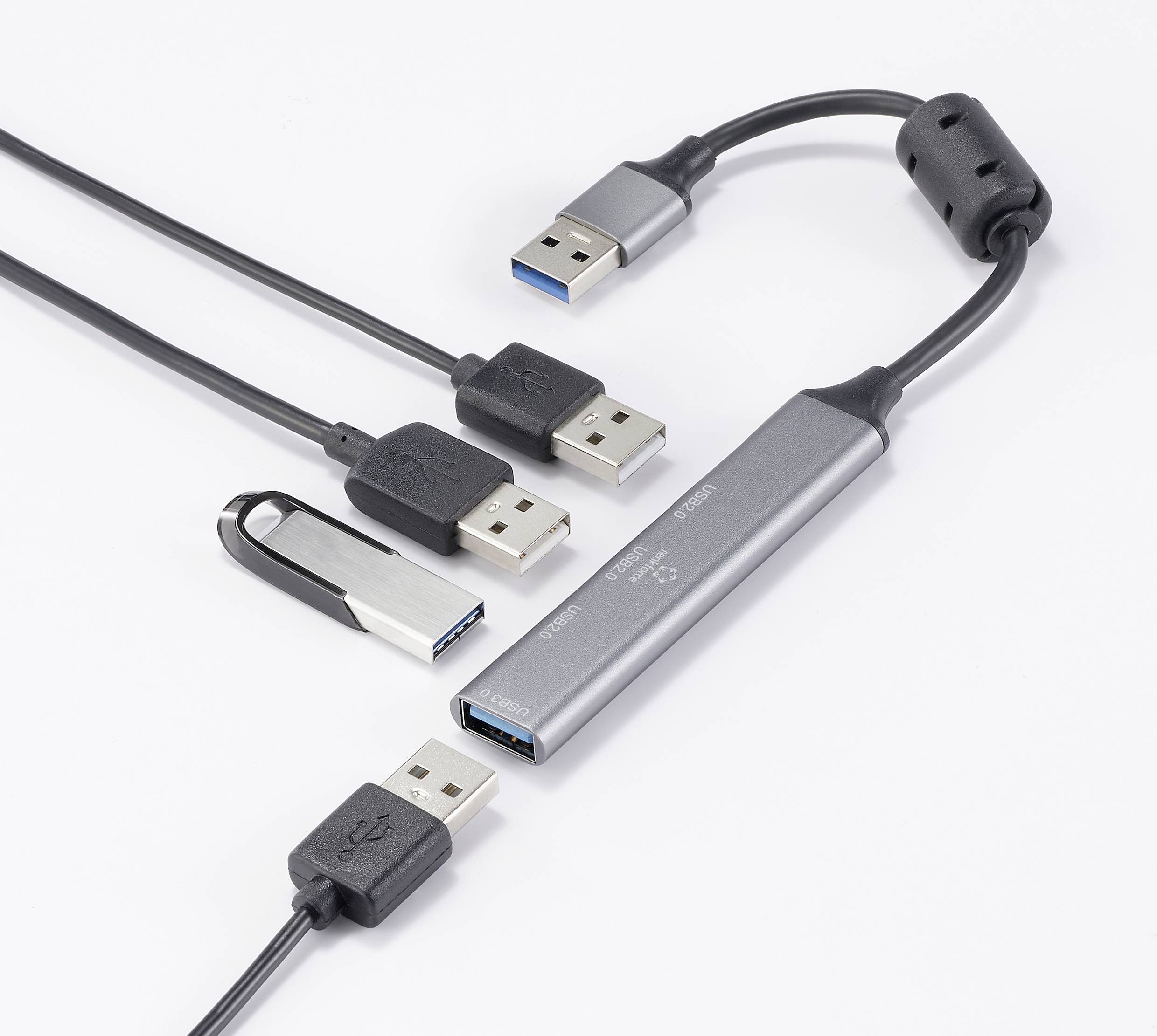 Ein USB-Hub mit mehreren Anschlüssen, an den verschiedene USB-Kabel angeschlossen sind, auf einer weißen Oberfläche.