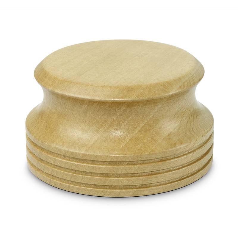 Ein runder, hölzerner Honigstößel mit gerilltem Design steht aufrecht.