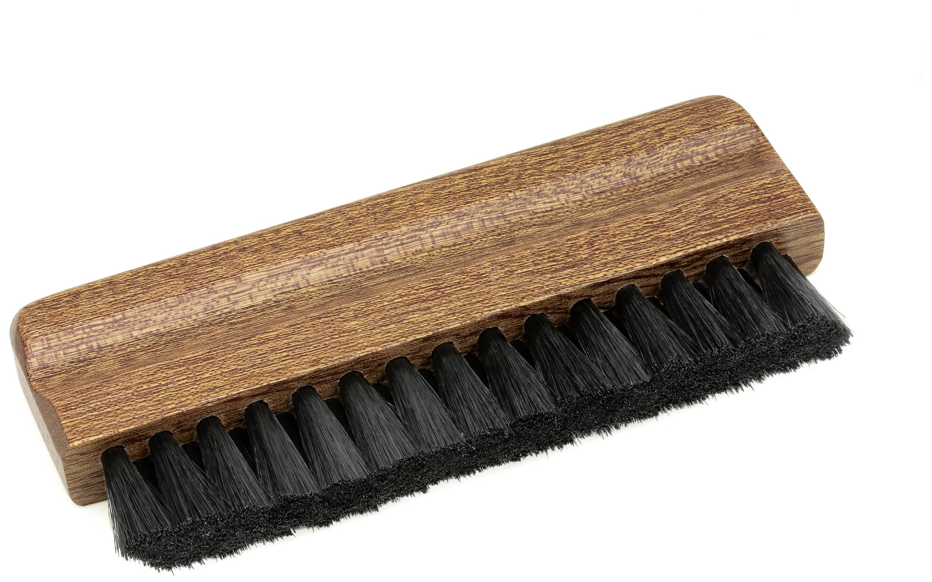 Holzbürste mit schwarzem Borsten zum Reinigen oder Polieren. Rechteckiges Design mit glatter Holzoberfläche und dichten Borsten.