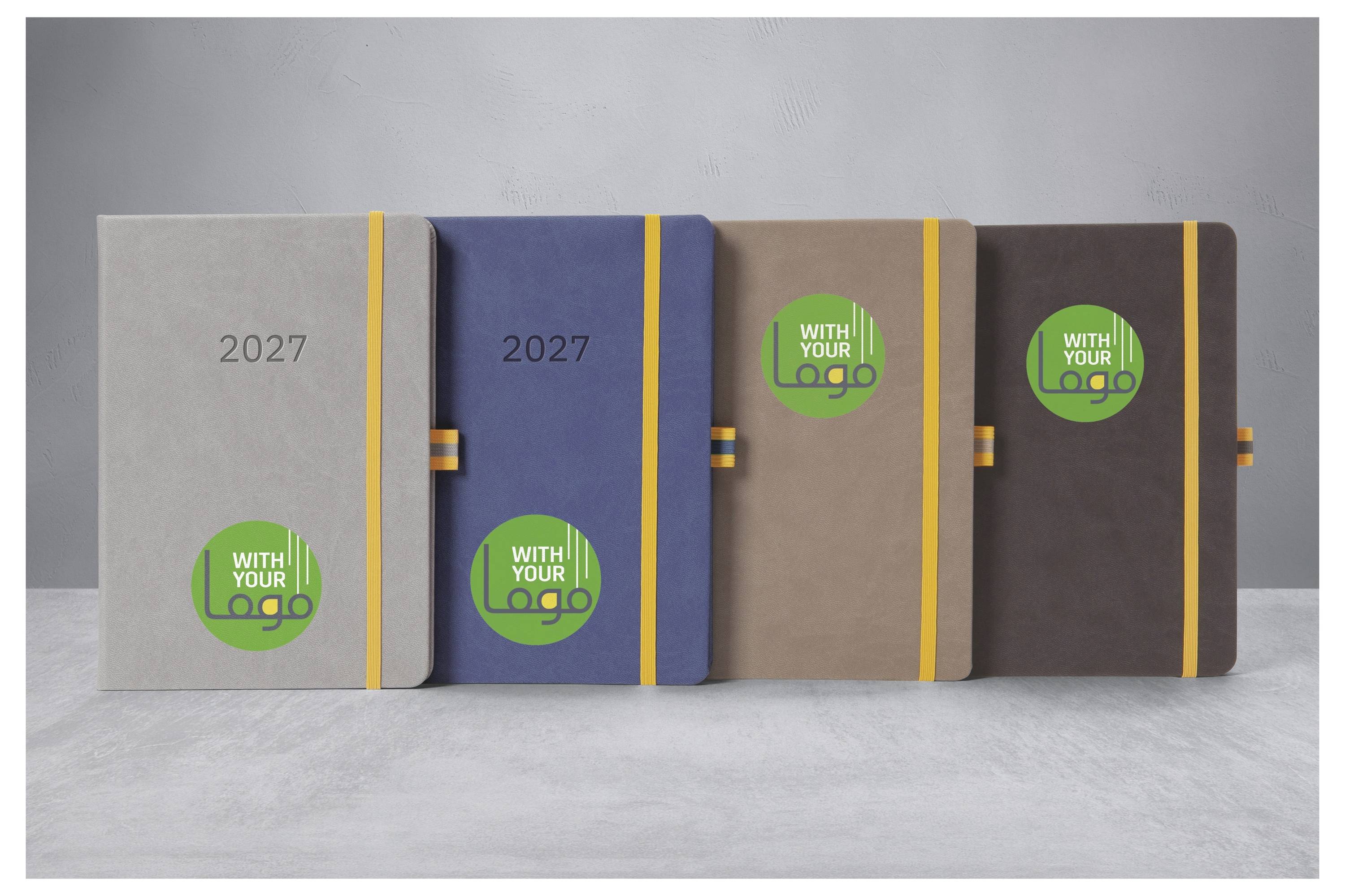 Vier 2027 Notizbücher in Grau, Blau, Tan und Braun, jeweils mit einem gelben Gummiband und einem „MIT IHREM Logo"-Kreis auf dem Umschlag.