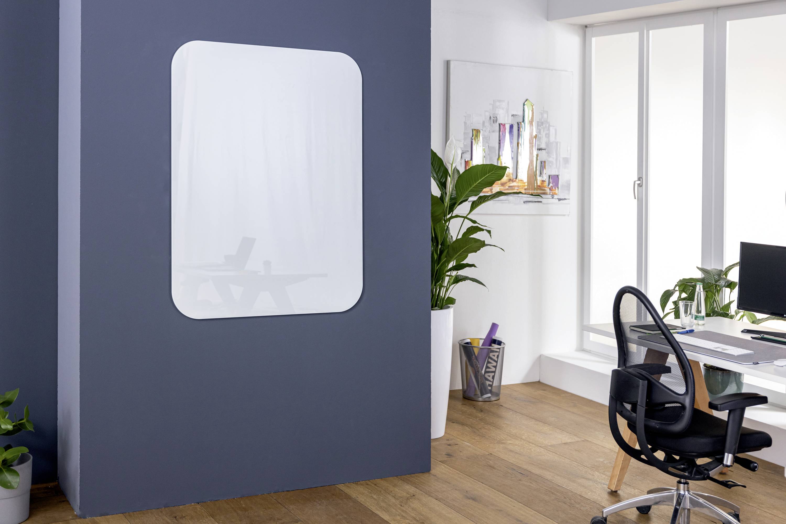 Helles Büro mit Holzfußboden, Glasfrontfenstern, einem Schreibtisch mit Stuhl, Pflanzen und einem großen, dekorativen Wandspiegel.