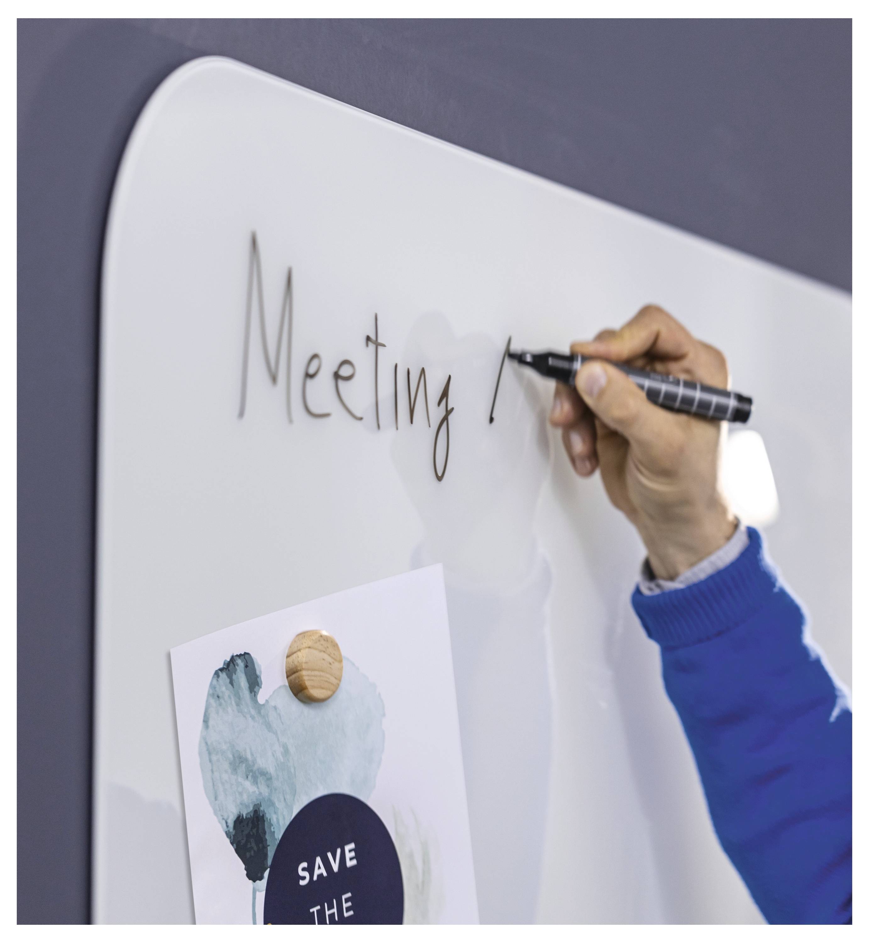 Handschrift „Sitzung" auf einem Whiteboard neben einer angehefteten Notiz, die auf Planung oder Brainstorming hindeutet.