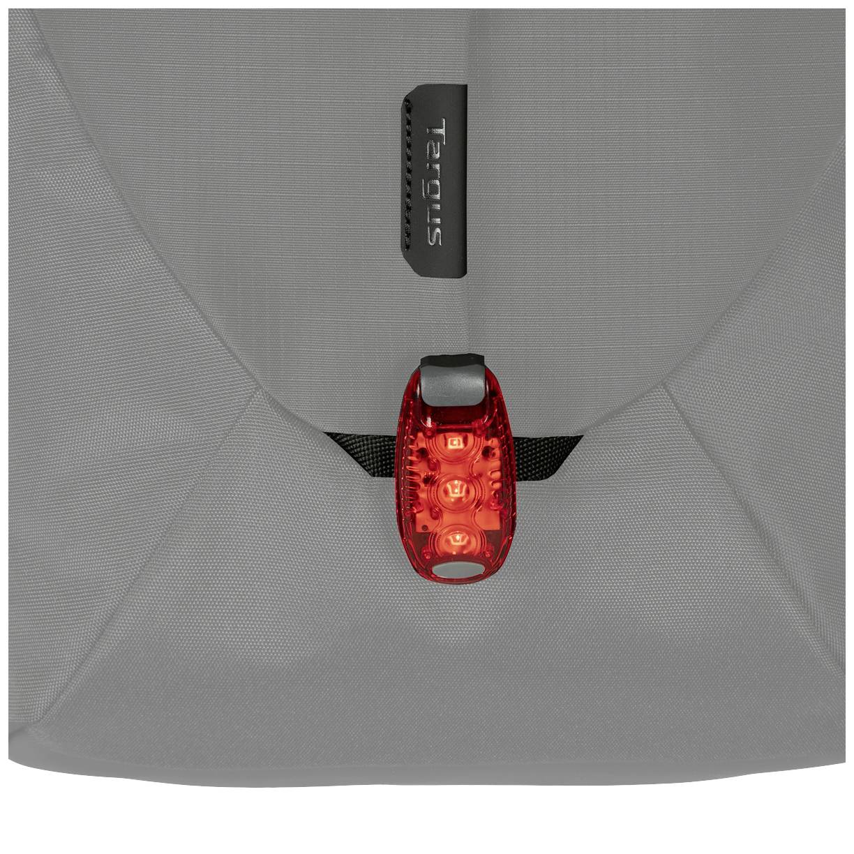 Eine Tasche mit einer leuchtend roten Fahrradlampe, die an der Rückseite befestigt ist, um die Sichtbarkeit zu erhöhen.