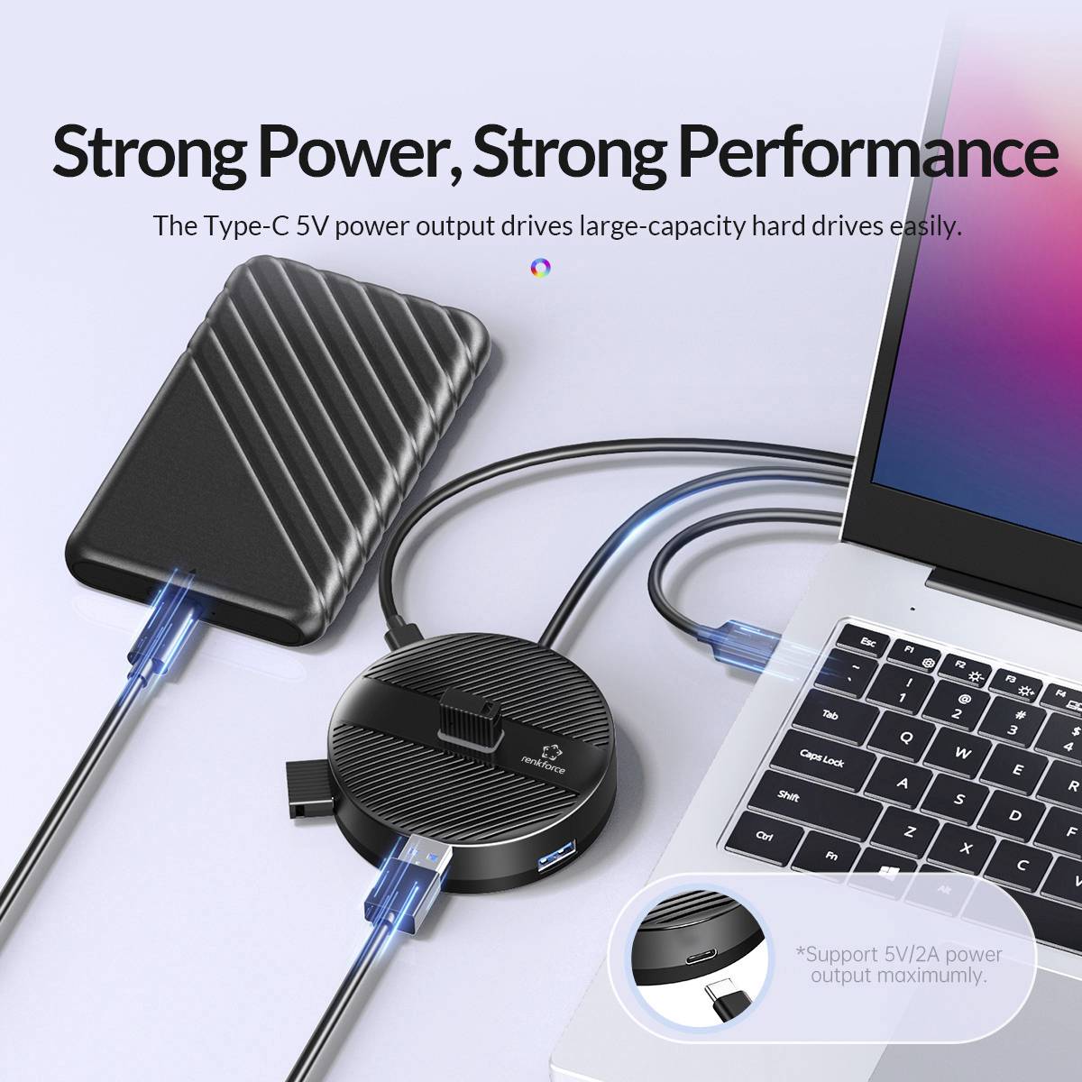 Ein schwarzes externes Laufwerk und ein USB-C-Hub liegen mit mehreren angeschlossenen Kabeln auf einer weißen Oberfläche. Text: 'Strong Power, Strong Performance'.