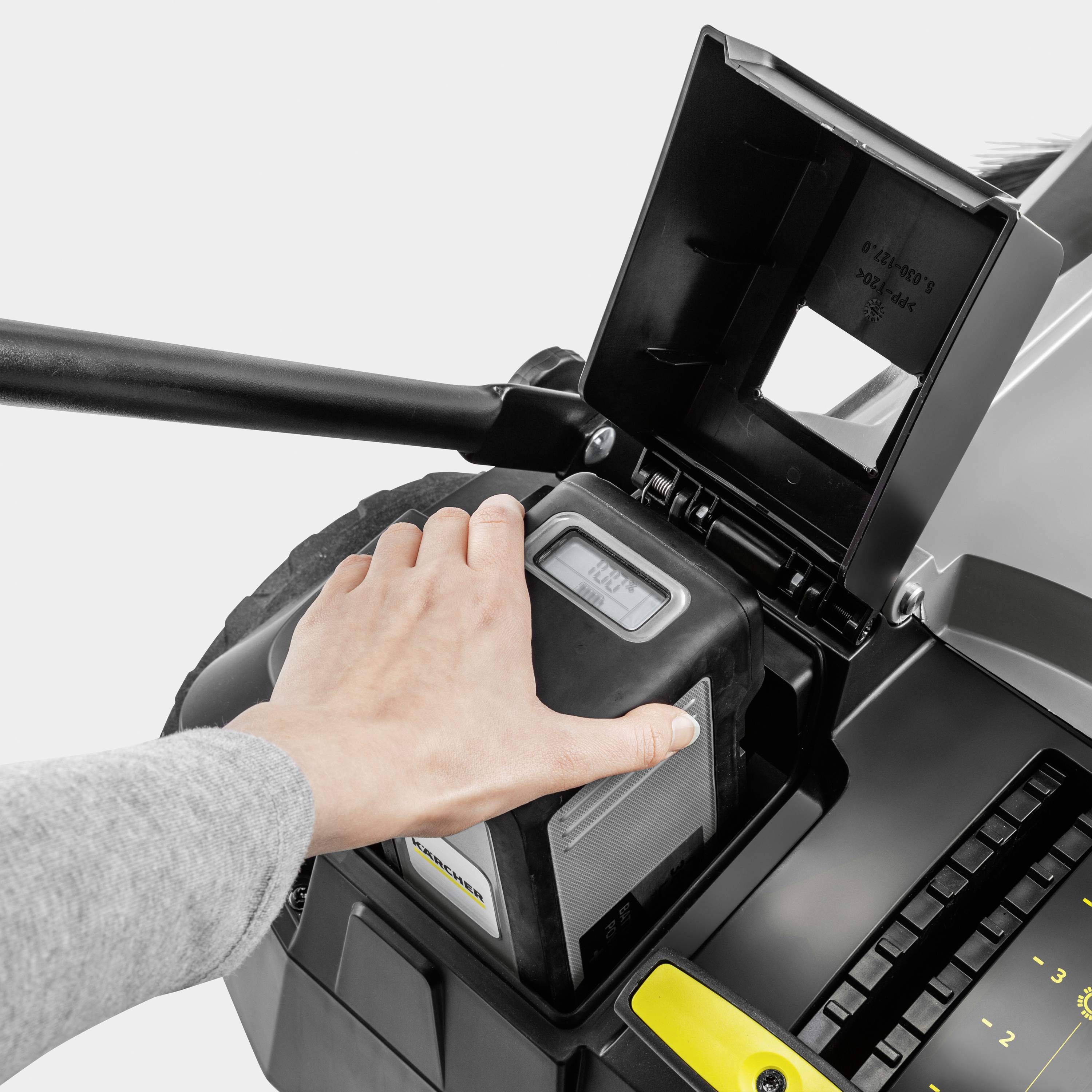 Hand bedient einen elektronischen Kontrollknopf einer Maschine mit digitaler Anzeige und offenem Fach.