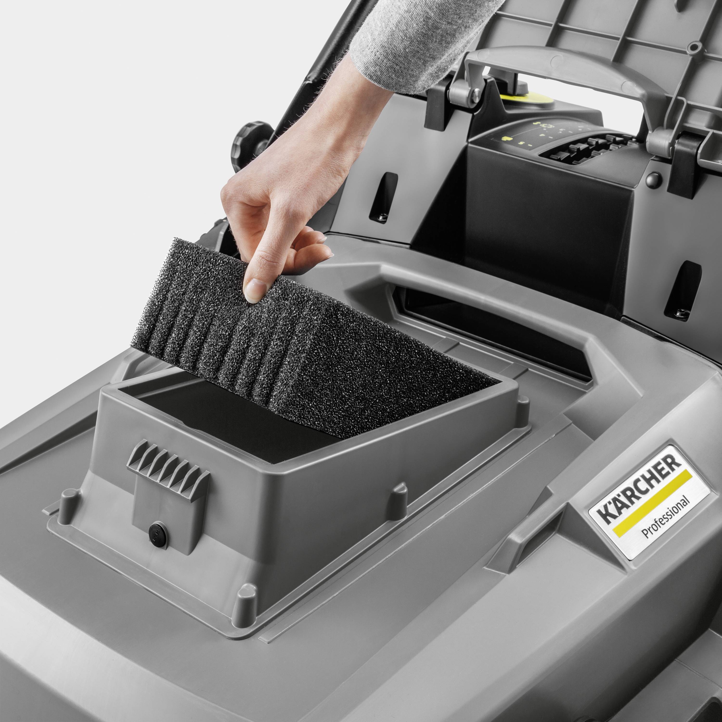 Eine Person ersetzt den Luftfilter in einem Kärcher Reinigungsgerät. Das Gerät ist offen, und der Filter wird in die vorgesehene Halterung eingesetzt.