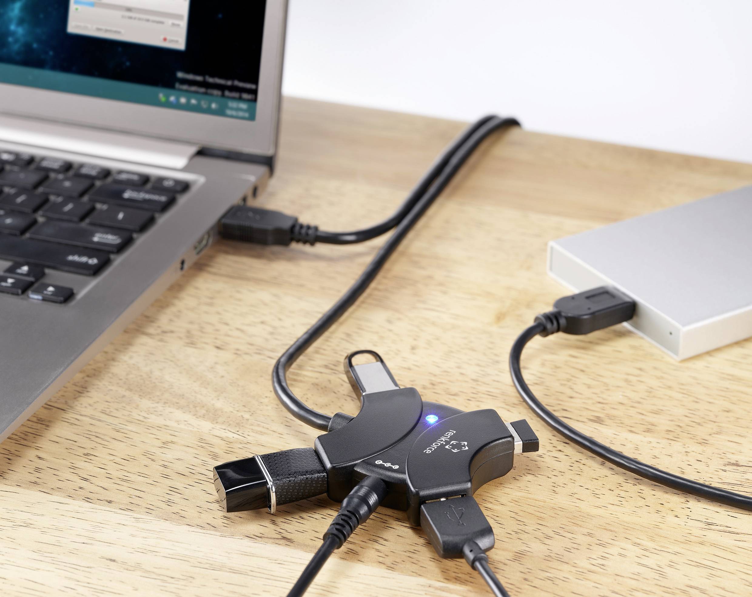 USB-Hub mit vier Geräten: Laptop, externer Festplatte, USB-Stick und Kabel. Zeigt Konnektivität und Funktionalität des Hubs.