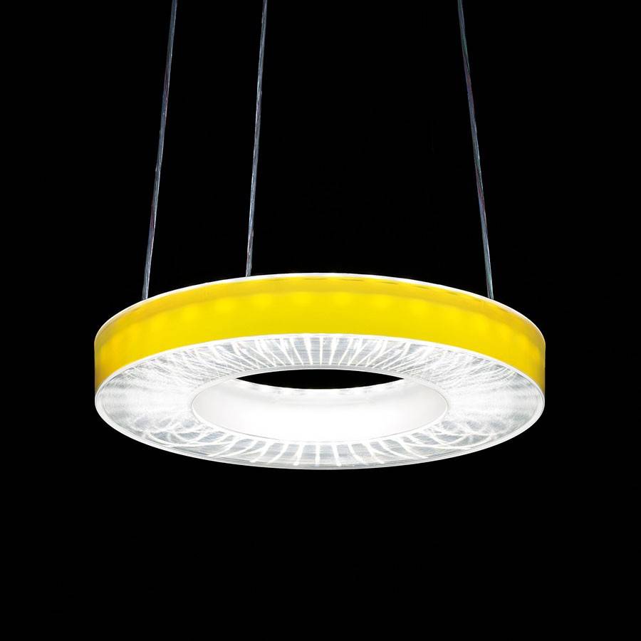 Eine runde, gelbe Pendelleuchte leuchtet in einem dunklen Raum. Sie hat ein modernes Design mit einem zentralen, hellen Licht.