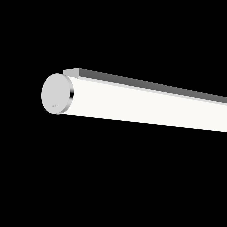 Eine moderne Linearleuchte mit silbernen Endkappen vor schwarzem Hintergrund. Sie beleuchtet gleichmäßig und ist minimalistisch designt.