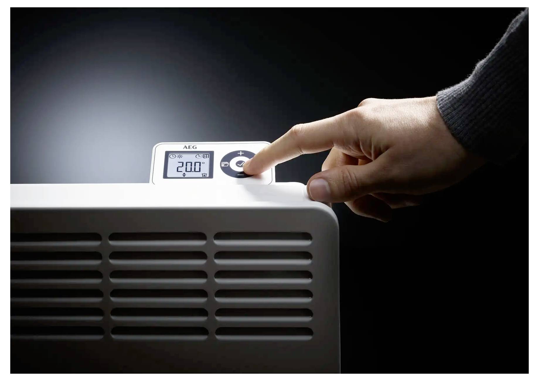Eine Hand stellt die Temperatur auf einer digitalen Heizeranzeige ein, die „20,0°C