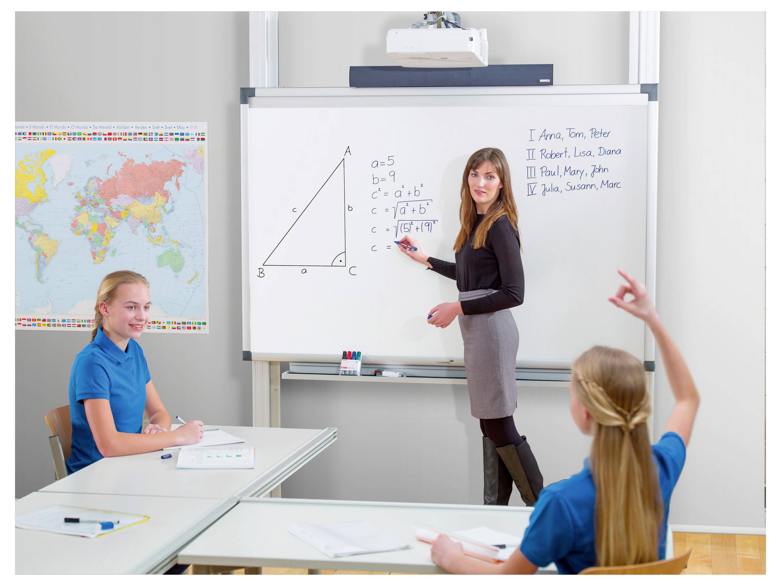 Ein Lehrer schreibt Dreiecksgeometrie-Formeln auf ein Klassenzimmer-Whiteboard, während Schüler an Schreibtischen sitzen und einer hebt die Hand.