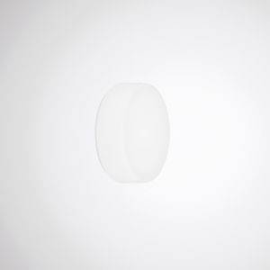 Runder, weißer, flacher Knopf oder Schalter an einer weißen Wand. Minimalistisches Design, könnte Dekoration oder Teil eines Geräts sein.