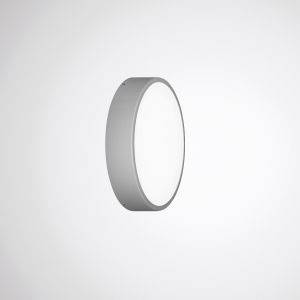 Eine runde, silberne Wandleuchte mit schlichtem, modernem Design leuchtet auf einer hellen Wand.