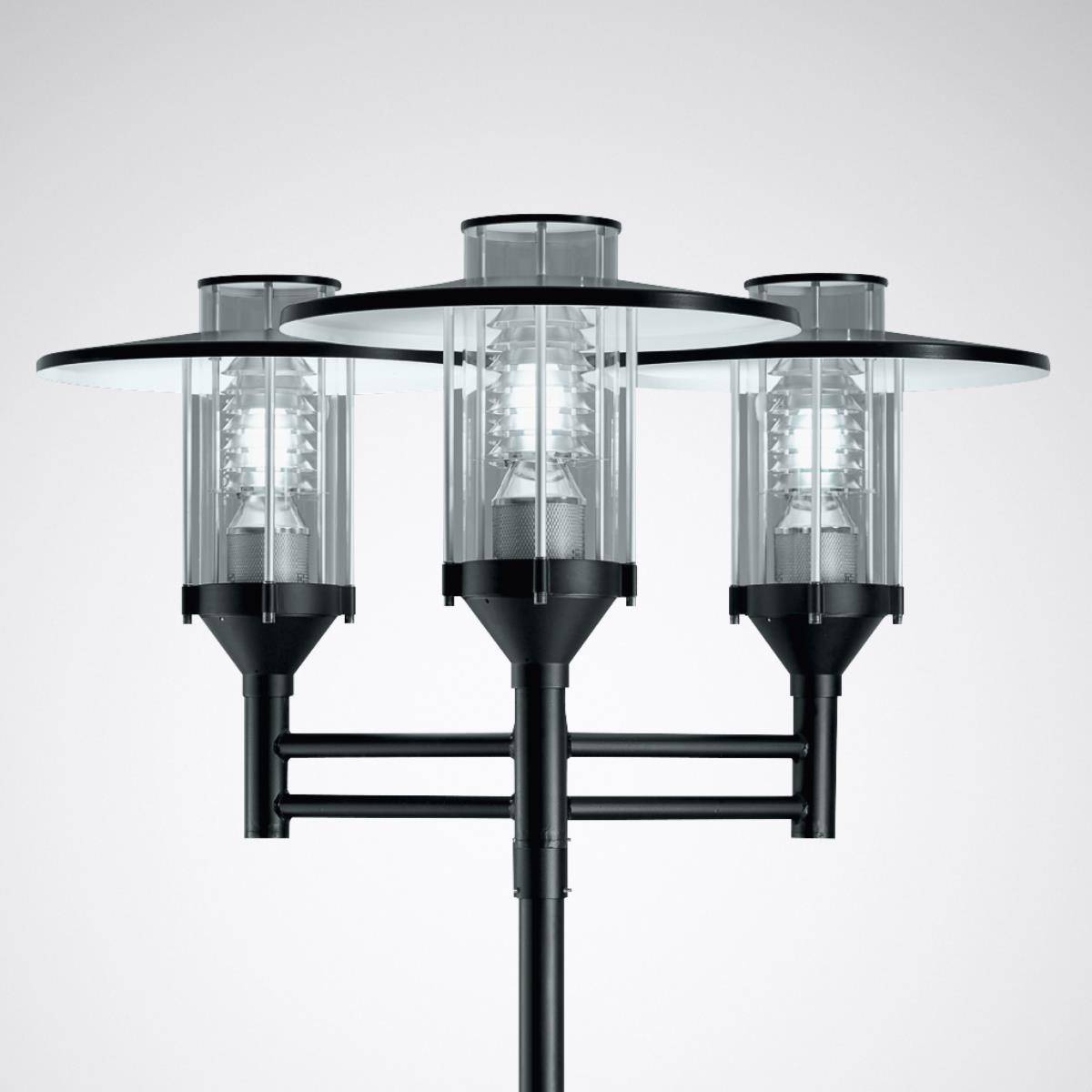 Eine moderne, dreifache Straßenlaterne mit vertikalen Glaszylindern und Metallrahmen, beleuchtet vor einem neutralen Hintergrund.