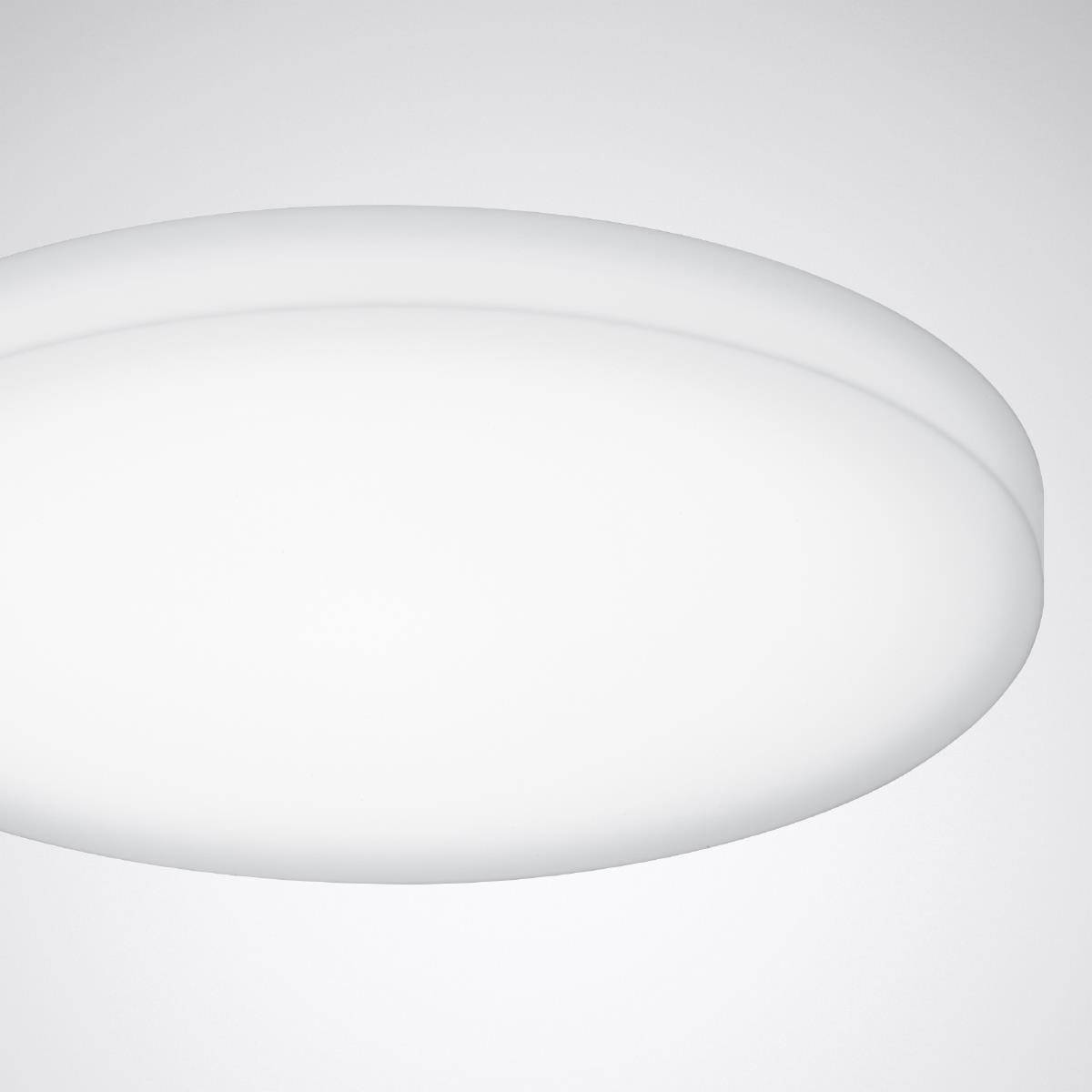 Eine schlichte, runde, weiße Deckenlampe leuchtet. Sie hat ein modernes, minimalistisches Design und befindet sich in einem neutralen Raum.