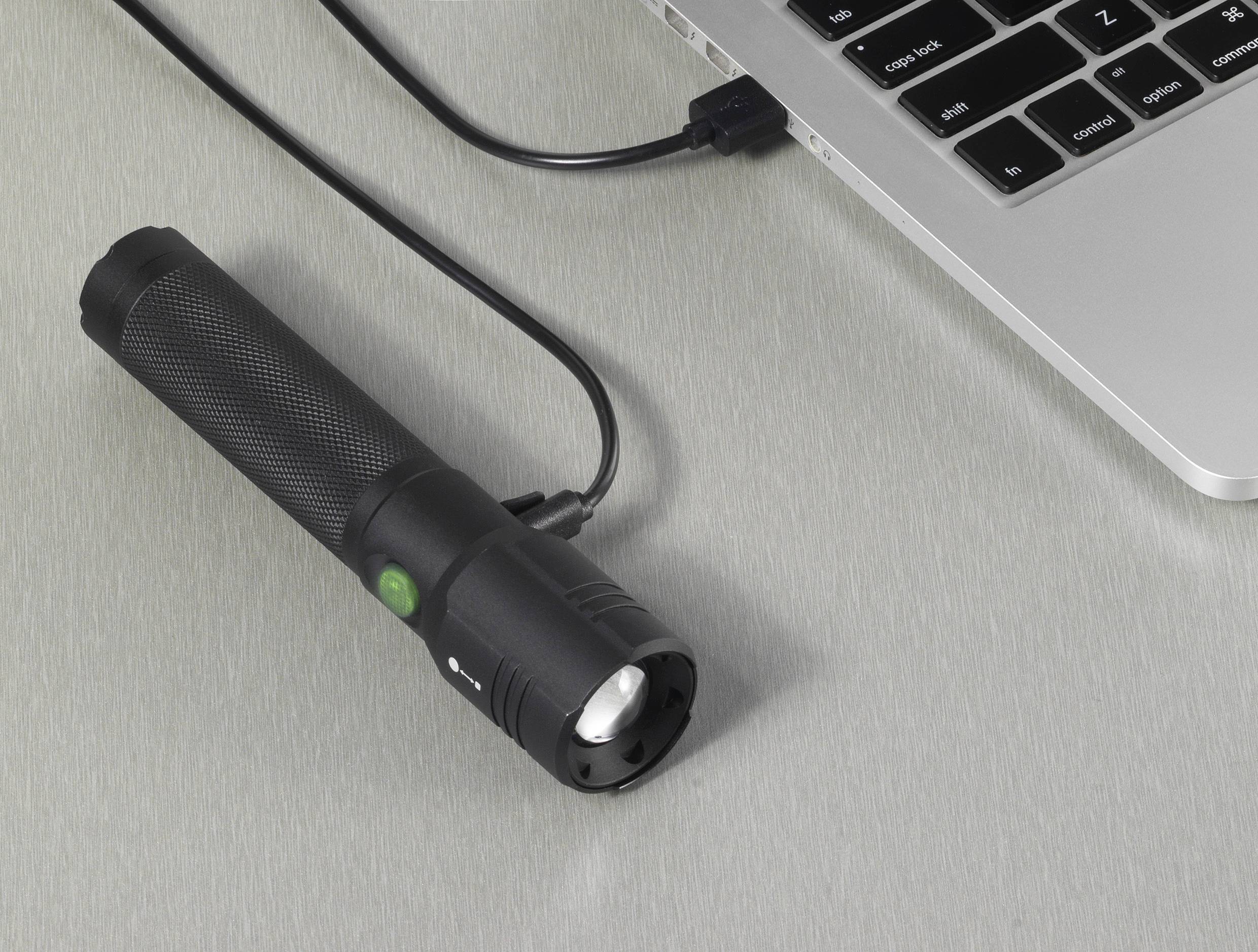 Eine Taschenlampe wird über ein USB-Kabel mit einem Laptop verbunden. Sie scheint nahe der Tastatur zu liegen.