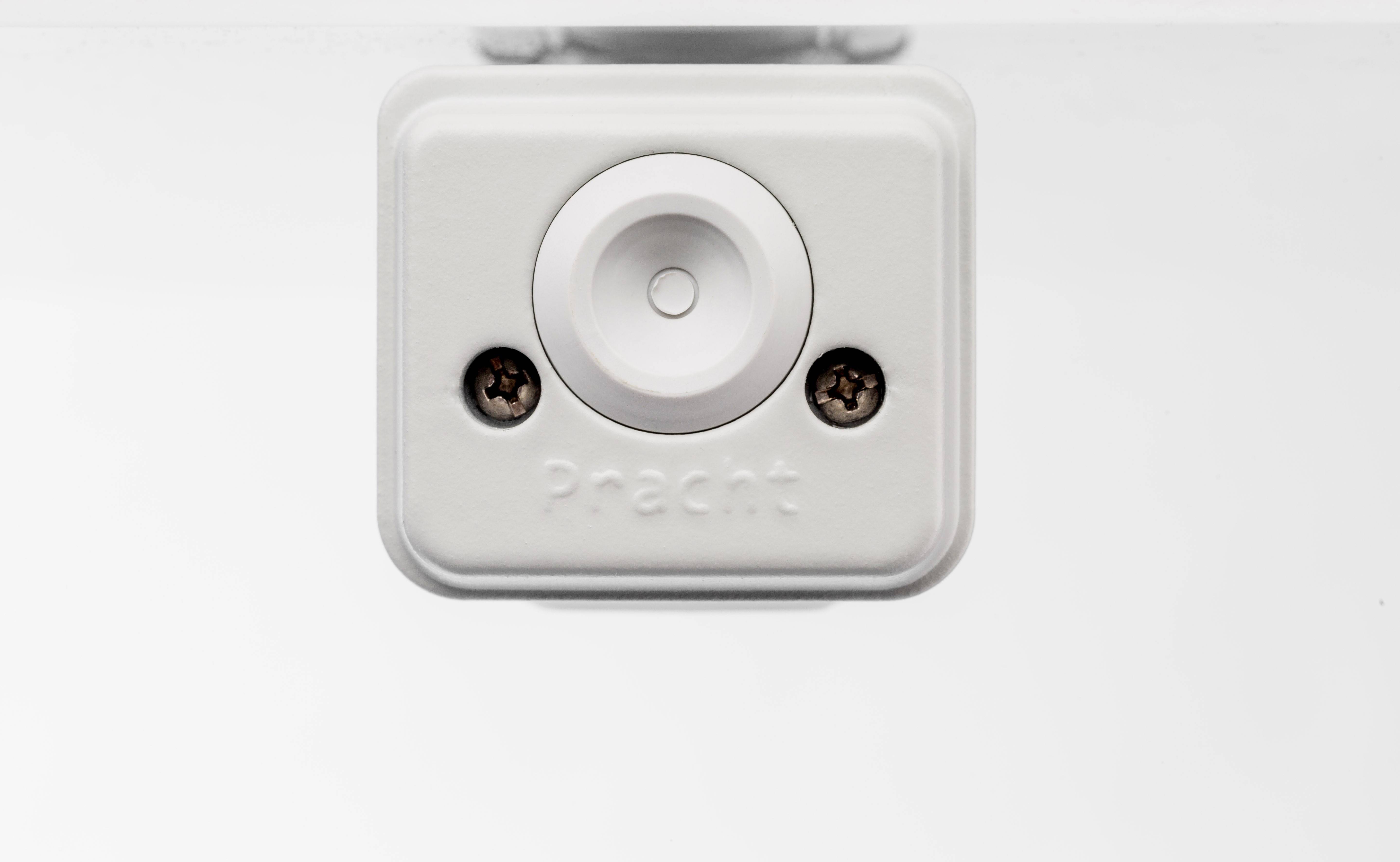 Ein quadratischer Sensor mit zwei Schrauben, mittigem Knopf und dem Wort 'Pracht' eingeprägt, auf weißem Hintergrund.