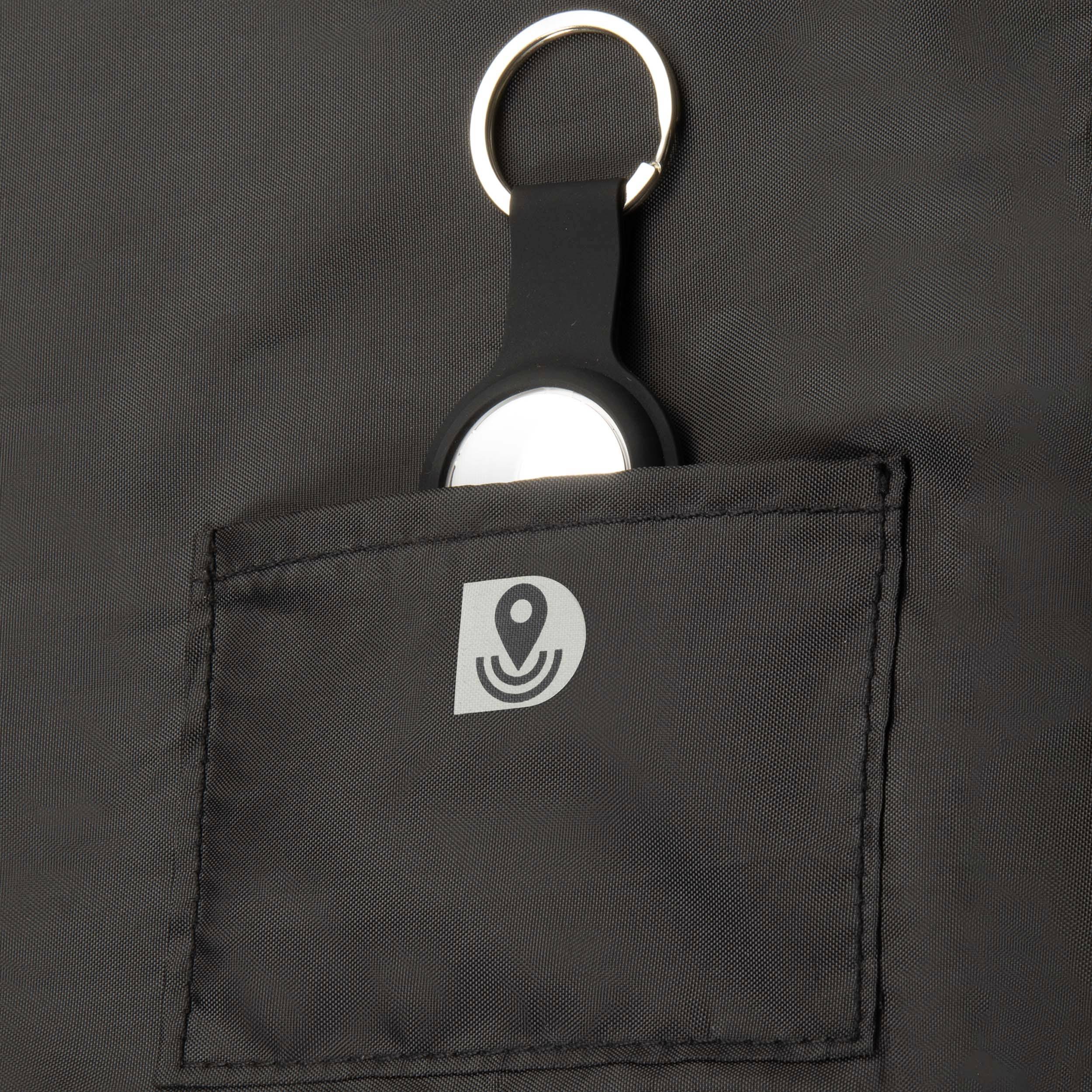 Ein schwarzer Schlüsselanhänger mit einem runden Metallelement steckt in der Tasche eines schwarzen Stoffbeutels.