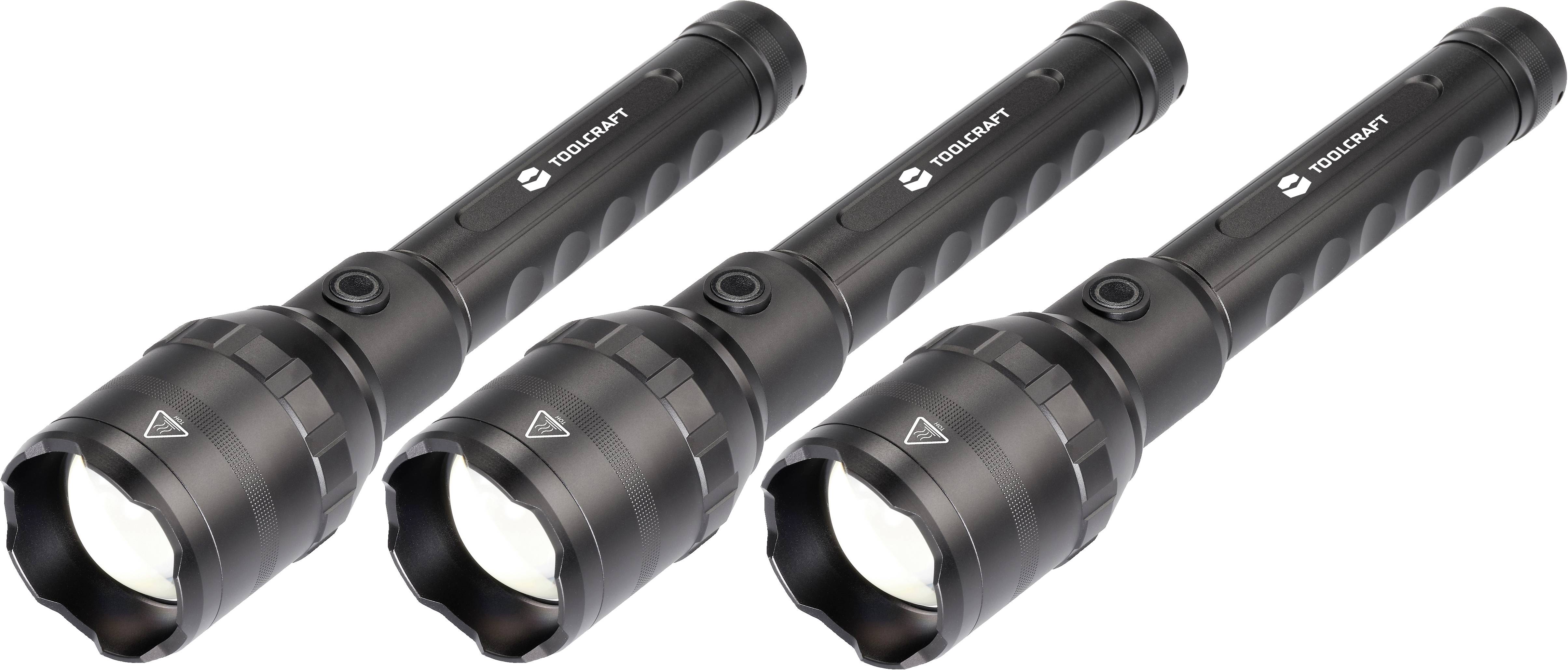 Drei schwarze Taschenlampen mit eingeschaltetem Licht liegen nebeneinander auf einem weißen Hintergrund.