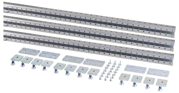 Mehrere lange, perforierte Metallschienen, Schrauben und Montageplatten auf weißem Hintergrund. Komponenten für Konstruktionsbau.
