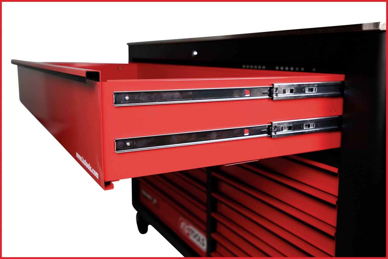 Eine rote Werkzeugschublade wird aus einem schwarzen Schrank gezogen, zeigt geöffnete Schubladenschienen und dahinter weitere Schubladen.