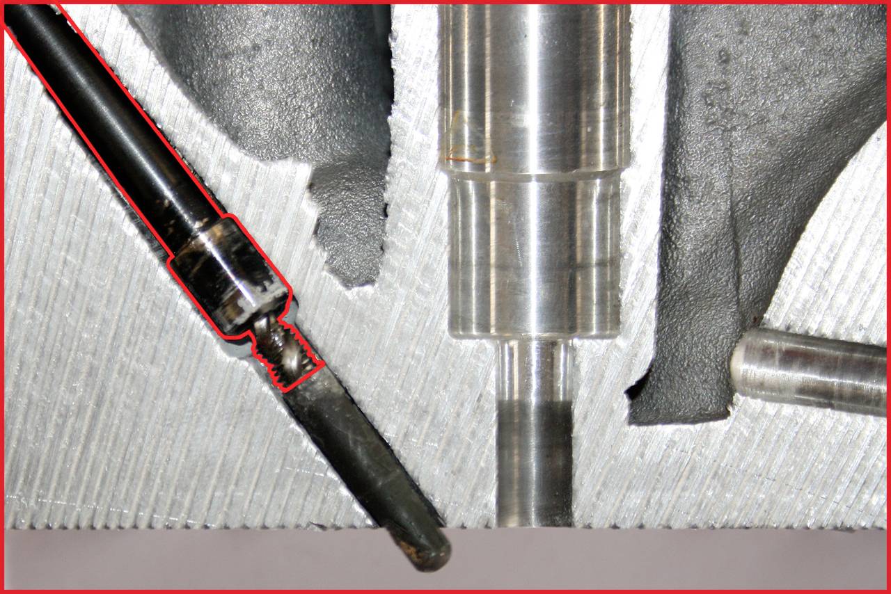 Nahaufnahme eines mechanischen Teils mit rauer Oberfläche. Links ist ein abgenutztes Metallwerkzeug zu erkennen. Aufnahme zeigt Schnittstelle und Details.