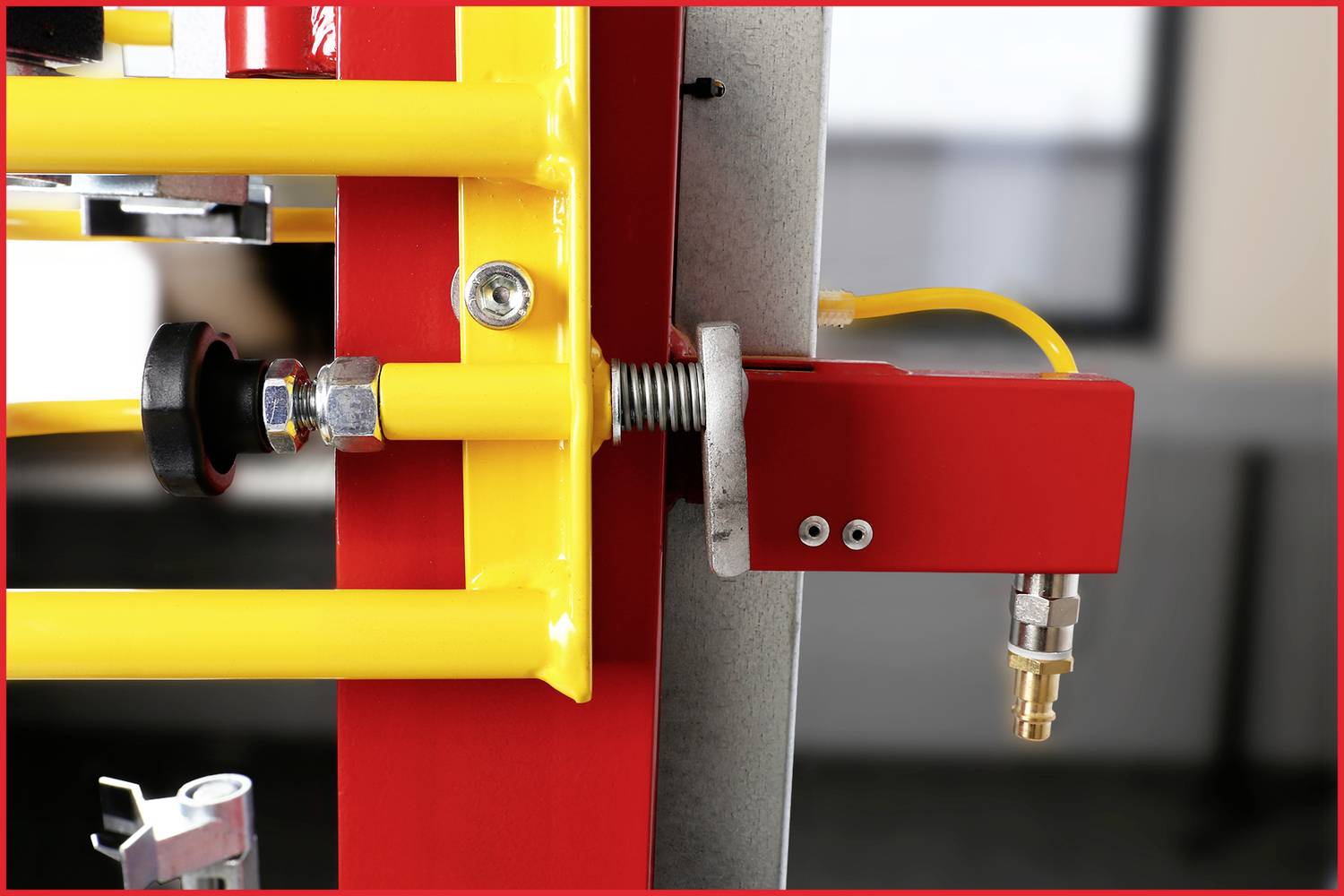 Ein Nahaufnahmebild zeigt ein rot-gelbes Sicherheitsventil oder einen Verschlussmechanismus, der an einem Metallrahmen befestigt ist.