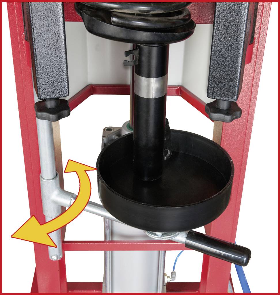 Hydraulische Presse mit einer schwarzen Platte und einem Hebel an der rechten Seite. Der Pfeil zeigt die Hebelbewegung an.