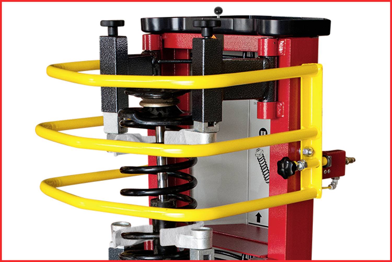 Maschine mit gelben Schutzgeländern zur Federkompression. Zeigt Teile der Feder und Sicherheitsvorrichtungen für Werkzeugeinsatz.