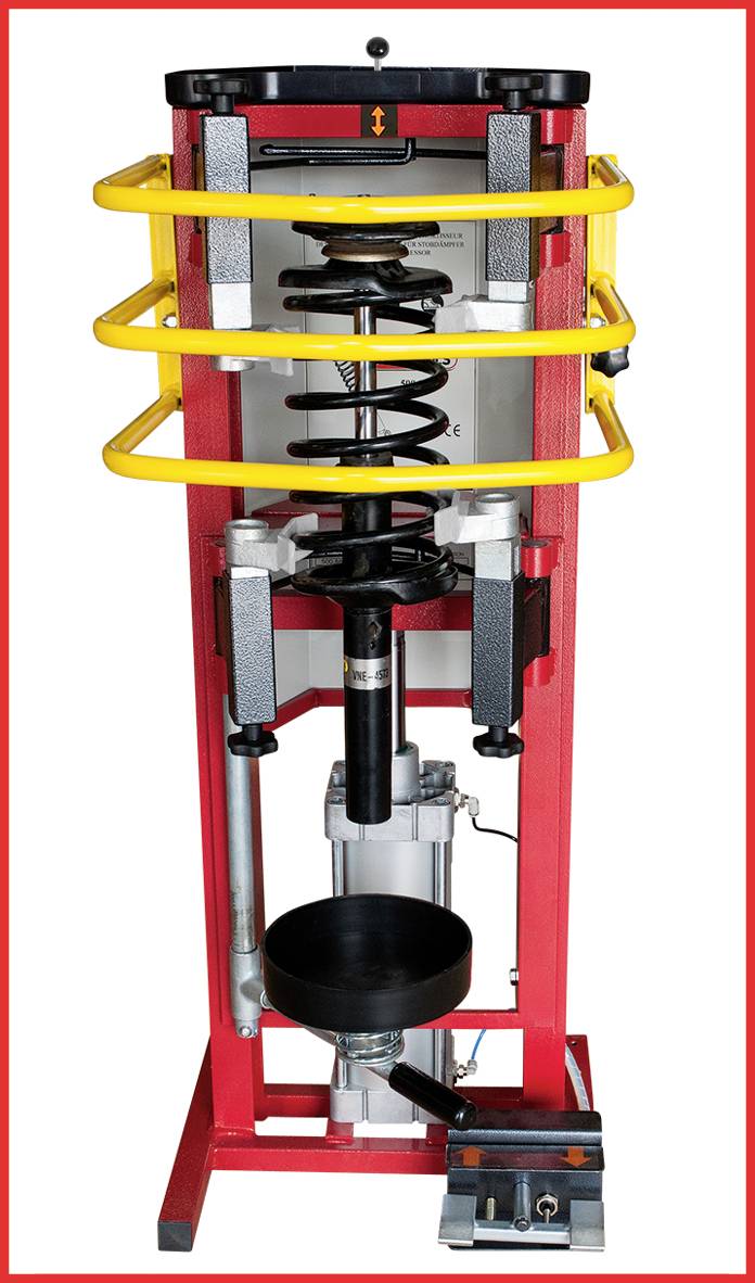 Maschine mit rot-gelbem Rahmen, zentraler Kolben und diversen mechanischen Komponenten. Industrielle Testvorrichtung, fokussiert auf Robustheit.