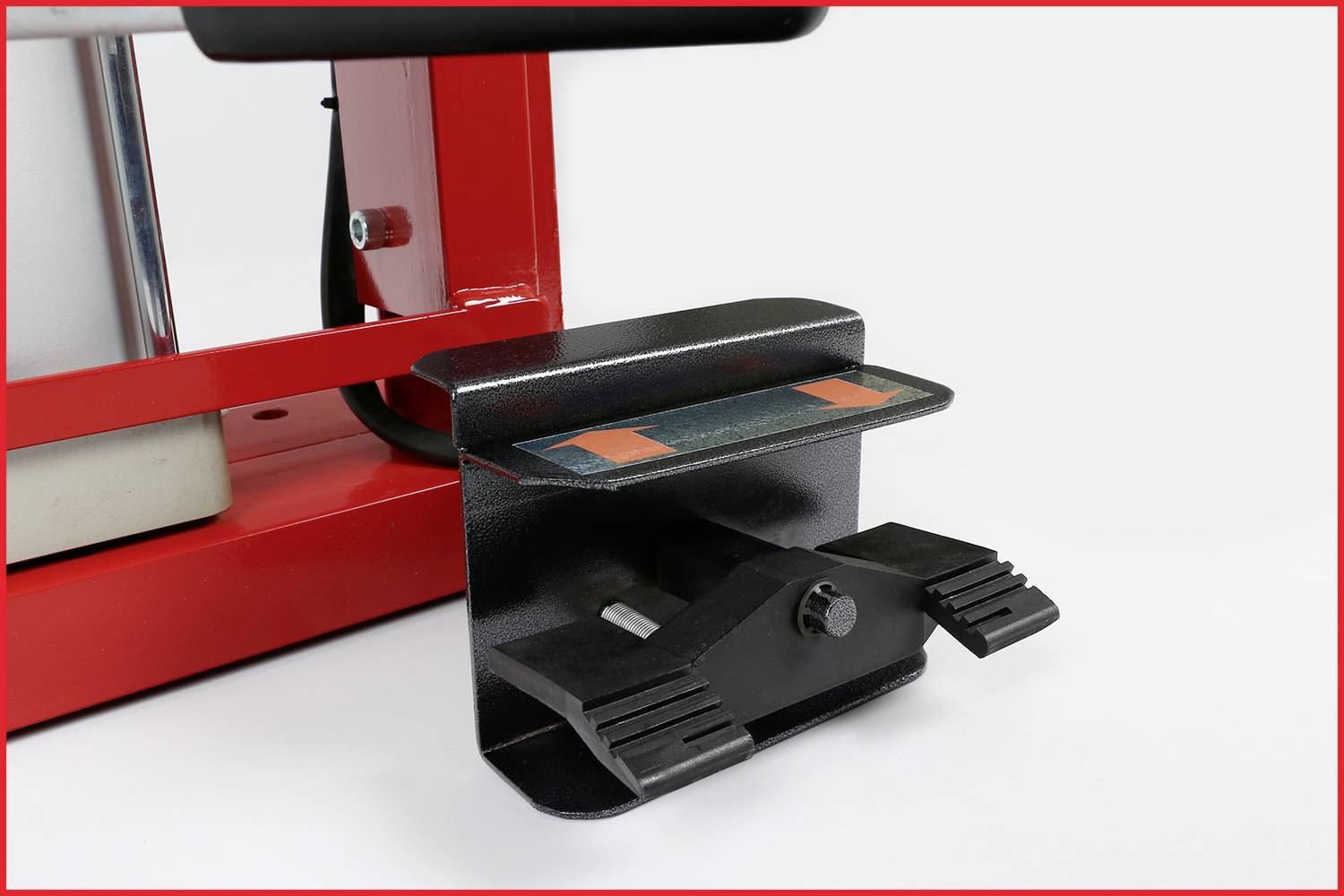 Fußpedal einer Maschine in Nahaufnahme, schwarz mit rotem Rahmen. Es hat zwei breite Pedale und eine rutschfeste Oberfläche.