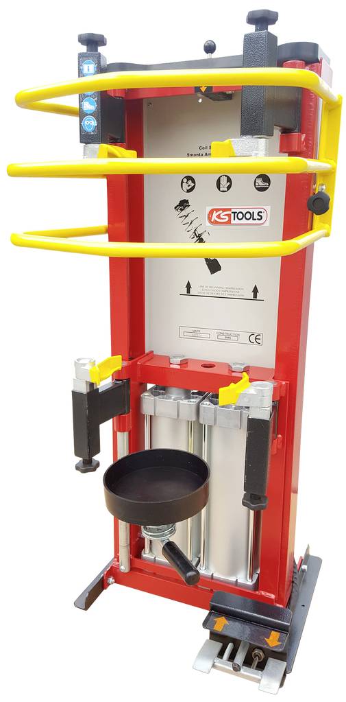 Eine rote hydraulische Federpresse von KS Tools, mit gelben Sicherheitsbügeln und Bedienungshebel, geeignet für Werkstattanwendungen.