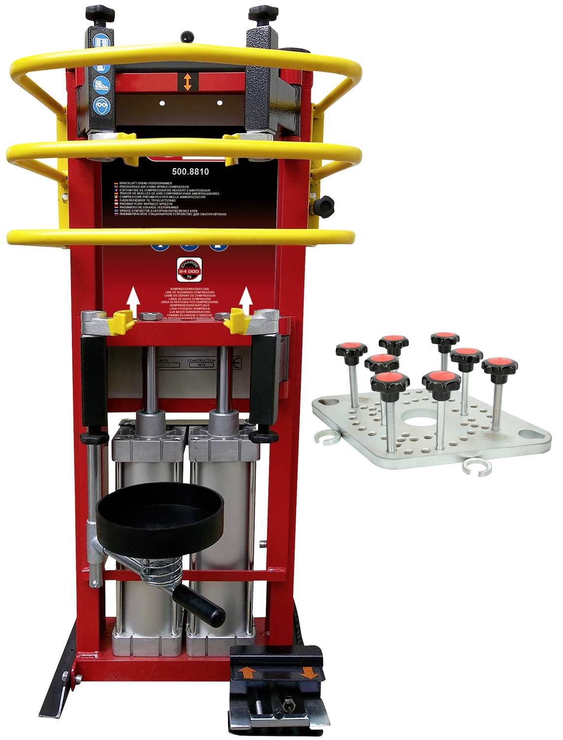 Ein rotes hydraulisches Werkzeug mit gelben Sicherheitsschienen, geeignet für Autowerkstätten. Rechts davon eine Halterung mit Bolzen.