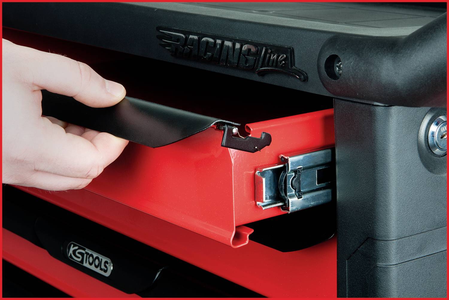Hand öffnet die Schublade eines Werkzeugwagens mit roter Schublade und schwarzer Griffleiste. Markenname und Schließmechanismus sichtbar.
